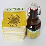 Bierflasche mit Bügelverschluss neben einem Stapel Bierdeckel